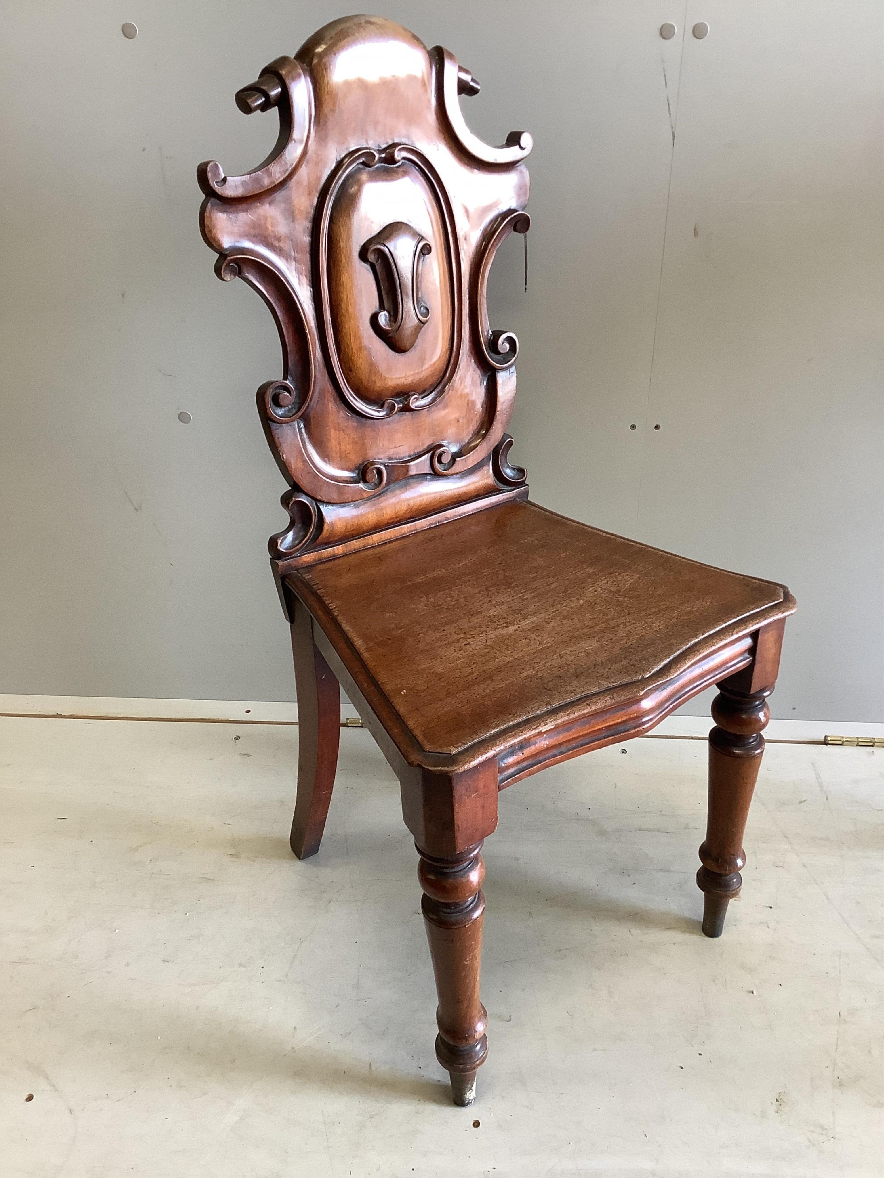 A pair of Victorian carved mahogany hall chairs, width 44cm, depth 39cm, height 90cm. Condition - poor to fair